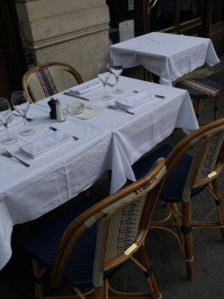 Mesa de restaurante contemporáneo con platos de cocina peruana y copas elegantes sobre madera oscura