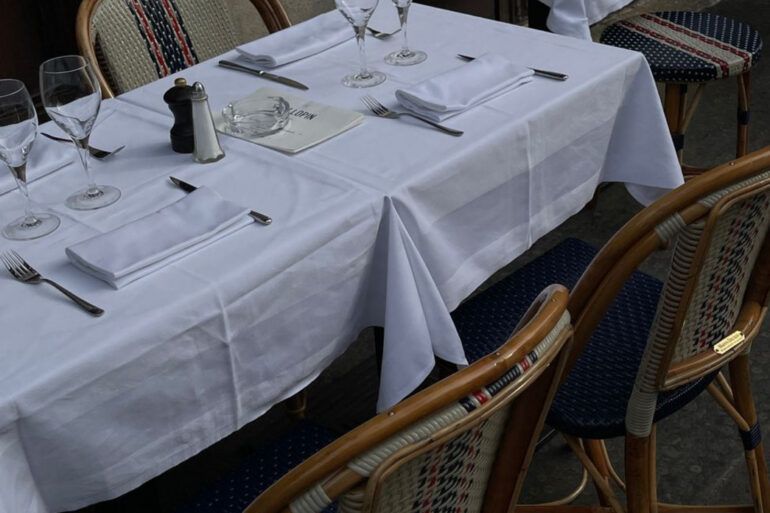 Mesa de restaurante contemporáneo con platos de cocina peruana y copas elegantes sobre madera oscura