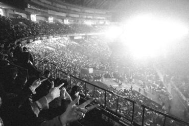 Concierto multitudinario en un gran estadio con luces de escenario y público disfrutando de la música en directo