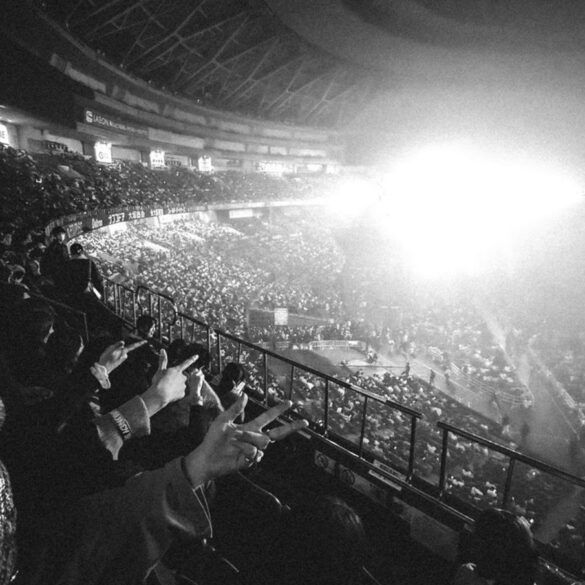 Concierto multitudinario en un gran estadio con luces de escenario y público disfrutando de la música en directo