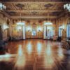 Salón de baile clásico con iluminación tenue y pista de parqué bajo luces doradas de atmósfera nostálgica