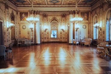 Salón de baile clásico con iluminación tenue y pista de parqué bajo luces doradas de atmósfera nostálgica