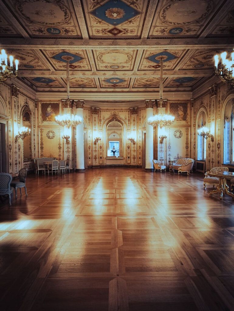 Salón de baile clásico con iluminación tenue y pista de parqué bajo luces doradas de atmósfera nostálgica