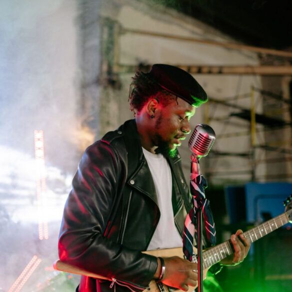 Micrófono clásico sobre un escenario oscuro iluminado con luces tenues de concierto de rock y poesía