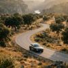 Coche elegante en una carretera secundaria atravesando un paisaje de dehesa dorada y colinas al atardecer de otoño