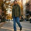 Look urbano de street style con chaqueta técnica utilitaria y pantalones vaqueros con refuerzo en la rodilla.
