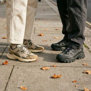 Primer plano de zapatillas urbanas de diseño con texturas y suelas gruesas sobre el pavimento de la ciudad.