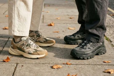 Primer plano de zapatillas urbanas de diseño con texturas y suelas gruesas sobre el pavimento de la ciudad.