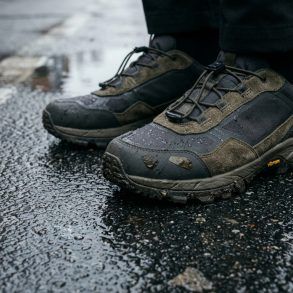 Detalle de zapatillas urbanas técnicas sobre suelo de asfalto mojado en la ciudad