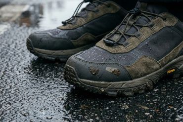 Detalle de zapatillas urbanas técnicas sobre suelo de asfalto mojado en la ciudad